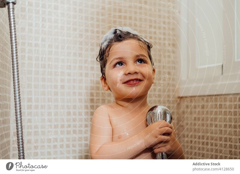 Cute boy singing in shower at home bathroom little foam smile child cute having fun kid cheerful content delight positive glad happy hygiene wet hair wash