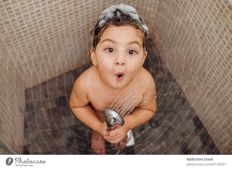 Cute boy singing in shower at home bathroom little foam smile child cute having fun kid cheerful content delight positive glad happy grimace baby hygiene
