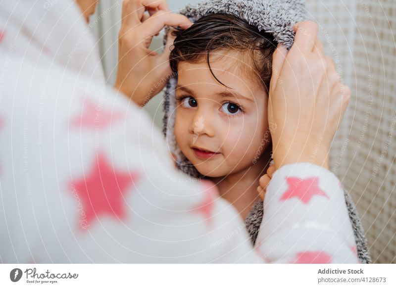 Delighted mother and son after shower in bathroom cuddle delight bathrobe boy little child kid smile content wet hair adorable embrace towel turban childhood