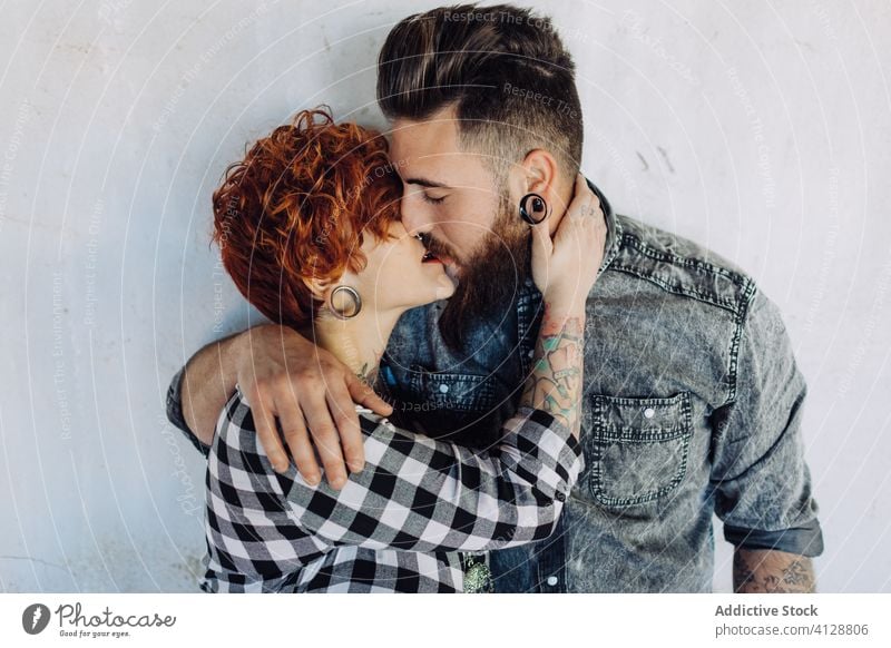 Happy young couple embracing near weathered building love embrace happy hipster street shabby together hug relationship tattoo boyfriend girlfriend affection