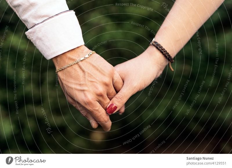 Couple Holding Hands Closeup closeup close up couple relationship holding hands together lovely front view background two family outdoors outside park nature