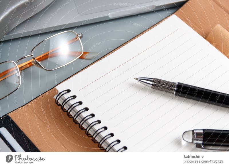 Opened agenda and pen on a grey close up Business opened write laptop planner office desk glasses smart working device gadget Modern Businessman Indoors