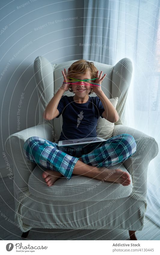 Boy with tablet playing string game kid learn cat cradle creative home boy device gadget internet using focus entertainment hands cheerful online sit
