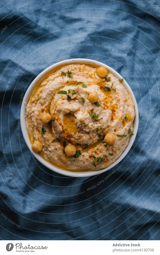 Homemade hummus on blue background appetizer bowl bread chickpea creamy dip food healthy homemade Hummus lunch olive oil paprika parsley snack tahini tasty