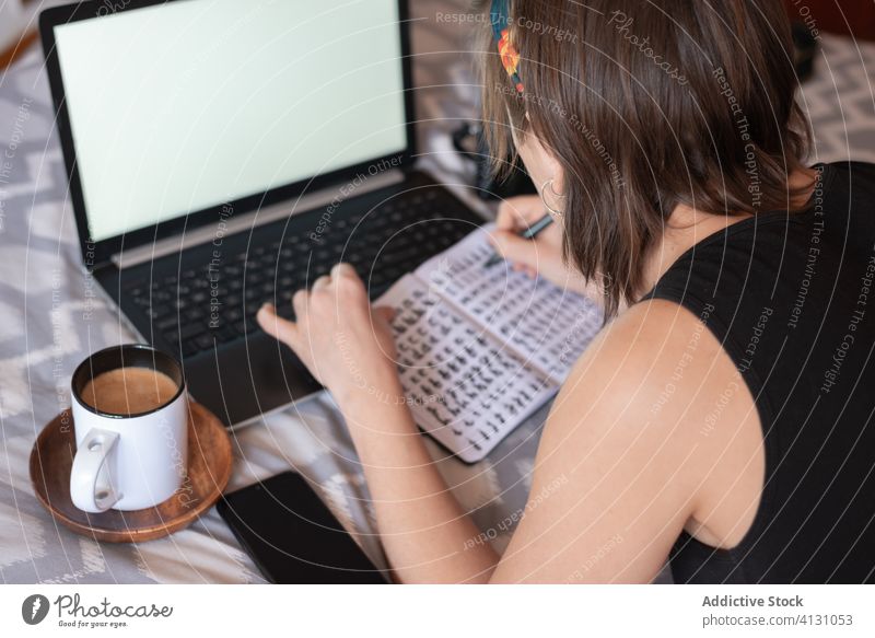 Woman taking notes in notebook in bedroom take note woman laptop coffee write notepad relax weekend female home cozy comfort soft lying casual outfit gadget