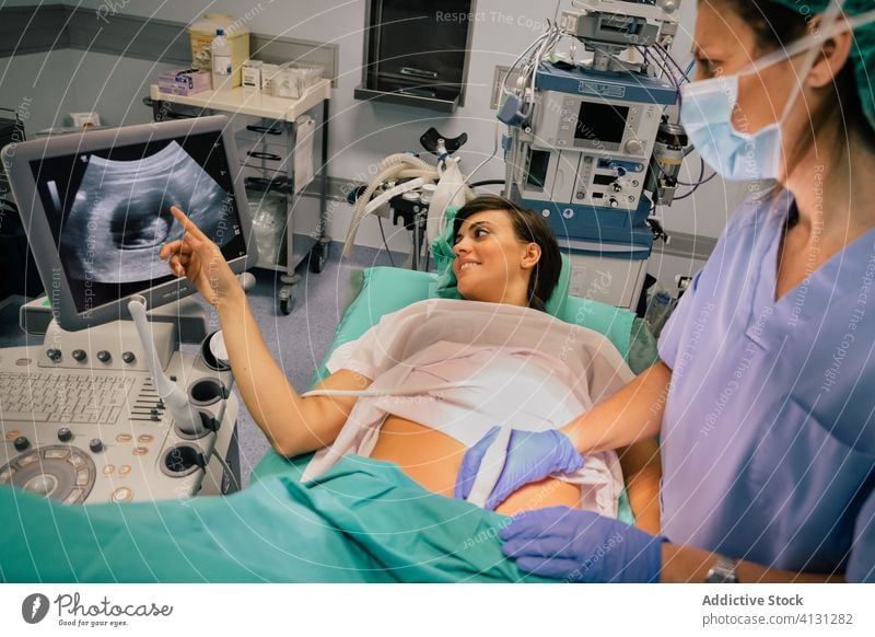 Gynecologist examining patient while doing ultrasound test in clinic gynecologist ultrasound scan women pregnant monitor embryo mask medical equipment examine