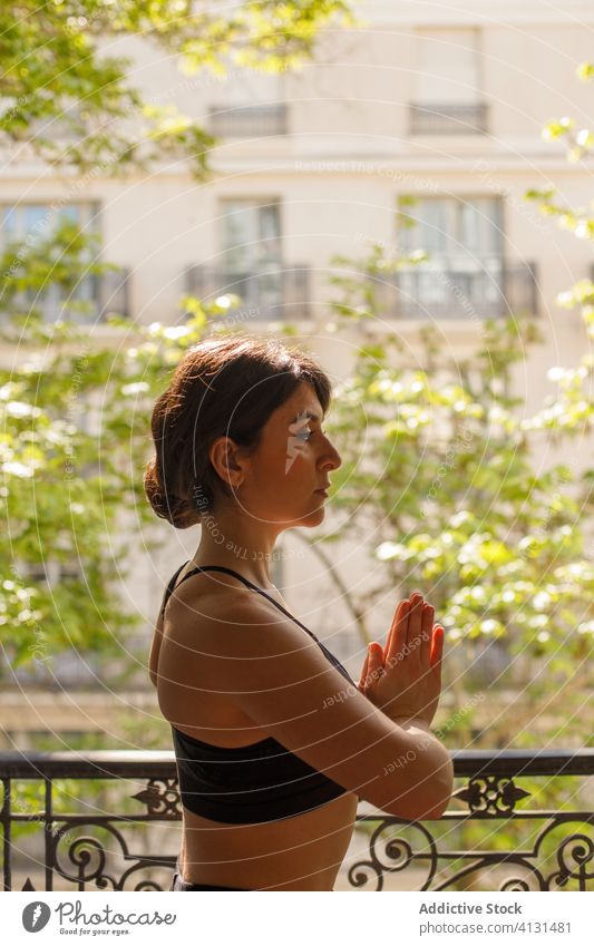 Calm female standing in eagle pose during yoga practice in summertime woman home meditate asana balcony calm peace mindfulness zen healthy lifestyle vitality