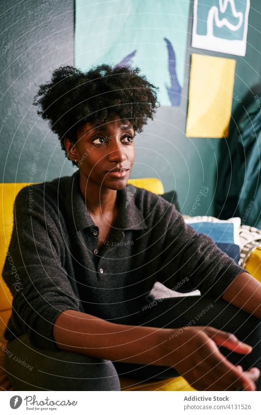 African American woman sitting at on couch home sofa casual african american young rest female lifestyle black ethnic apartment cozy lady calm modern