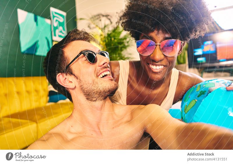 Smiling couple taking selfie during home party inflatable pool stay at home self isolation smile enjoy social distancing take photo having fun multiethnic