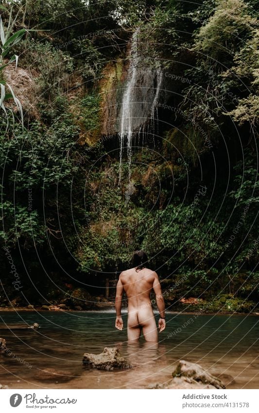 Man taking bath in waterfall pool forest man naked refresh small tropical plant stream jungle male travel tourism nature environment recreation wash nude