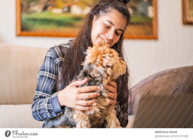 Cheerful woman with dog at home happy pet together enjoy friend young laptop female animal domestic lifestyle cheerful smile cozy love owner rest companion