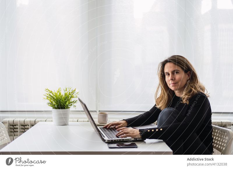 Remote employee working with laptop at home woman using online remote busy casual table electronic internet connection read workplace freelance device gadget