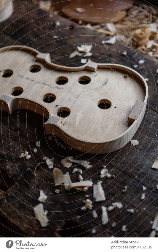 Soundboard of handmade violin on shabby wooden surface in workroom soundboard process workshop hole tool craft sawdust instrument workmanship create detail