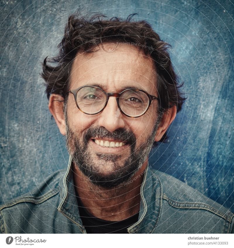 portrait of a friendly 50 year old man Man 50 years laughing smilingly likeable Blue jeans Eyeglasses Facial hair Positive happy glasses model Model Actor