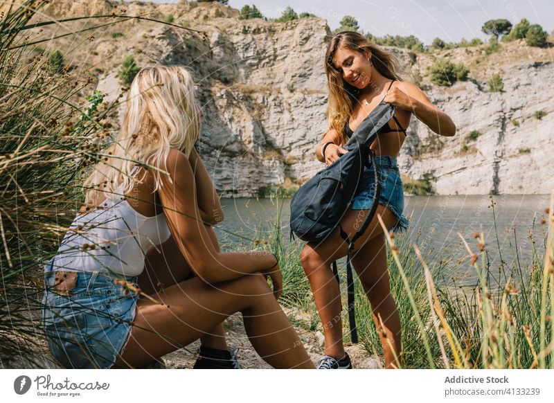 Traveling female friends near lake in summer vacation women together relax travel tourism shore content water nature rest coast holiday weekend happy carefree
