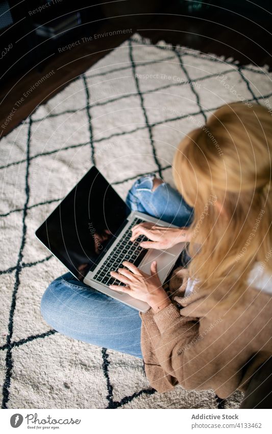 Busy female freelancer typing on computer thoughtful woman laptop project using work online self employed browsing cozy floor apartment sit carpet internet