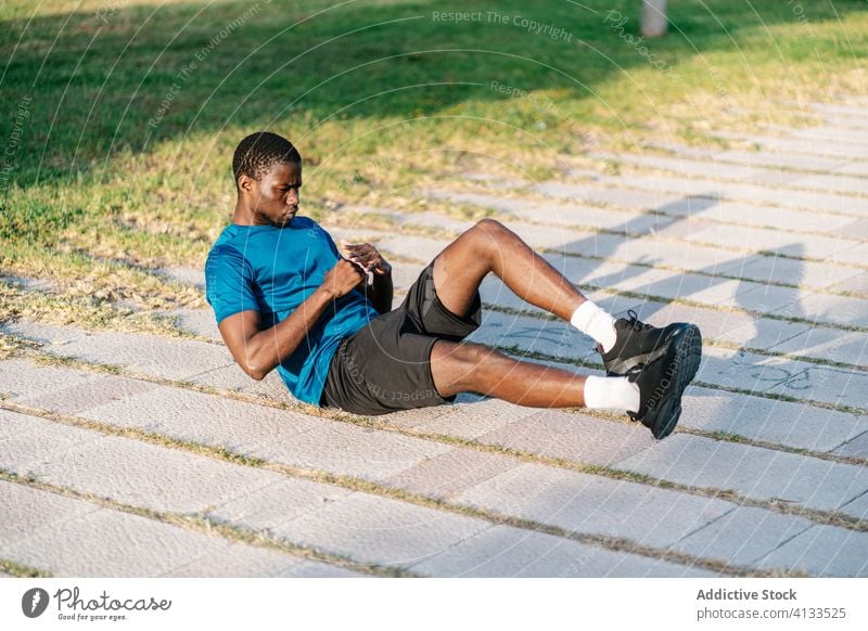 Athletic black man working out at park african exercise fitness floor workout body abs abdominal person healthy training muscle people sport young lifestyle