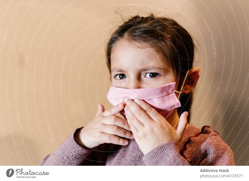 Unhappy girl wearing medical mask on street during coronavirus pandemic kid child face mask covid 19 ethnic unhappy casual childhood disappoint upset frown