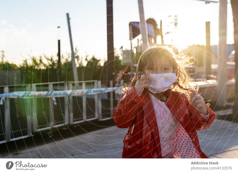 Ethnic girl in surgical mask on street" medical child enjoy weekend covid 19 protect ethnic childhood kid cheerful happy smile city stand safety care healthy