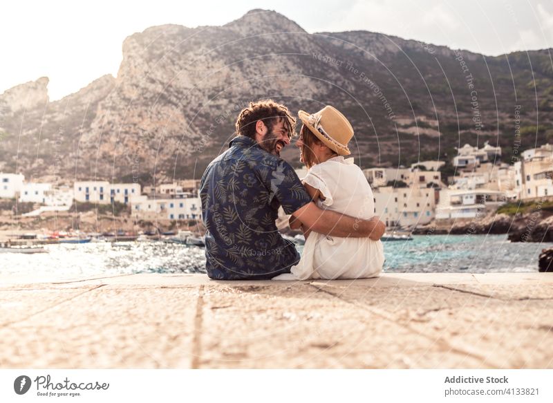 Loving couple hugging on stony hill near sea seascape travel majestic vacation together rocky levanzo island tourism cheerful journey romantic relationship