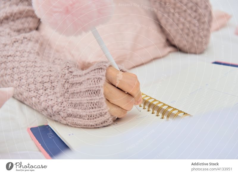 Woman taking notes in diary on bed take note woman notebook cozy dream write lying relax tea notepad female soft sweater comfort home casual rest bedroom memo