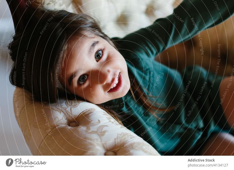 Adorable girl relaxing on sofa kid lying couch cozy weekend rest smile adorable child chill comfort cheerful joy home lounge carefree delight pleasure content