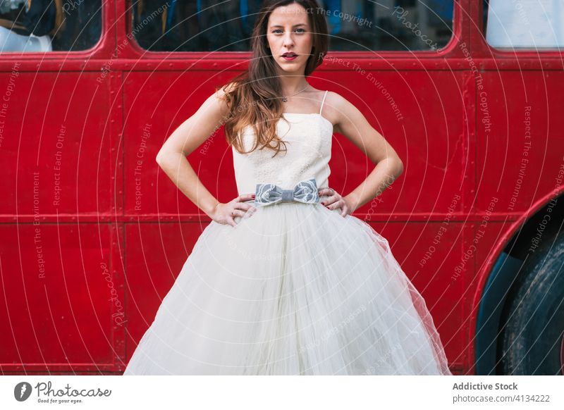 Serious bride standing near red double decker bus newlywed red bus wedding wood wedding dress retro serious unemotional female elegant forest wedding day