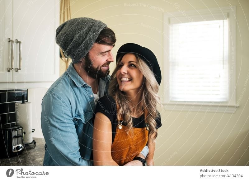 Happy couple embracing standing in the kitchen at home embrace relationship positive hipster style boyfriend affection fondness together love girlfriend partner