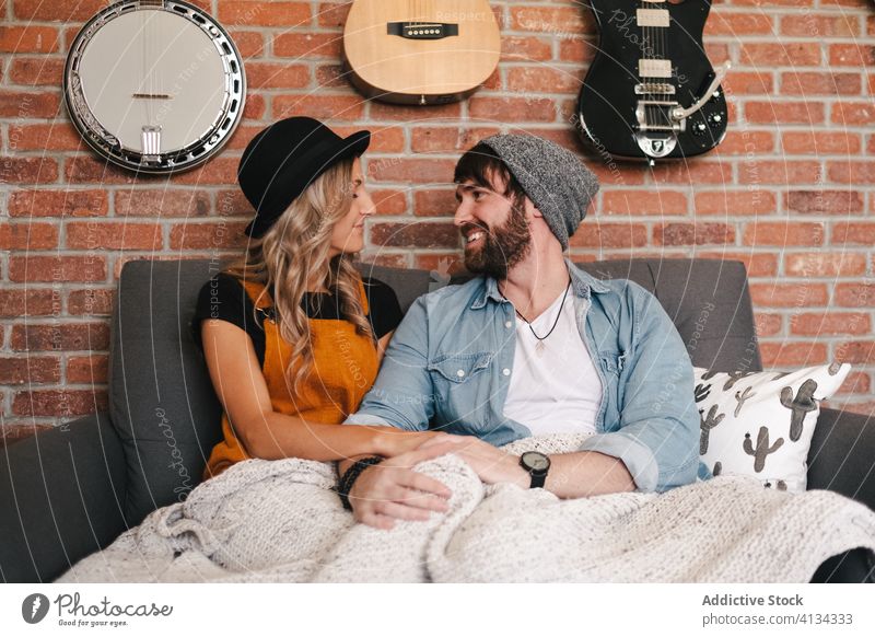 Happy couple with closed eyes resting on sofa at home embrace love cuddle hipster loft boyfriend affection fondness together positive girlfriend partner