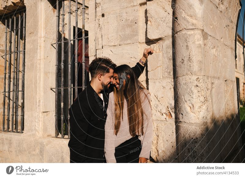 Happy young couple in love near weathered building together happy relationship romantic stone enjoy date romance ethnic affection cuddle cheerful boyfriend