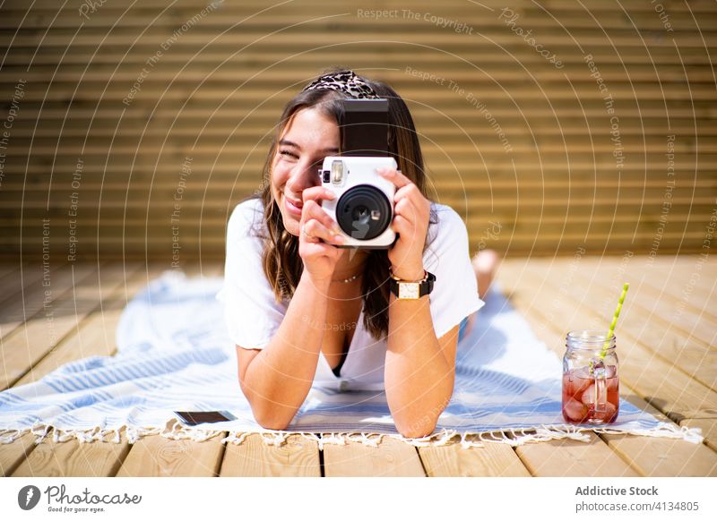 Cheerful woman taking photo take photo summer cheerful instant photo camera happy young positive female sunny terrace rest lifestyle vacation holiday smile joy