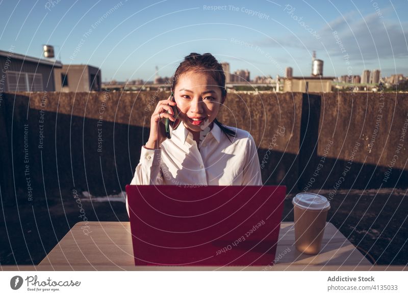 Busy woman with laptop working on rooftop smartphone using talk businesswoman formal device gadget asian young female internet communicate browsing connection