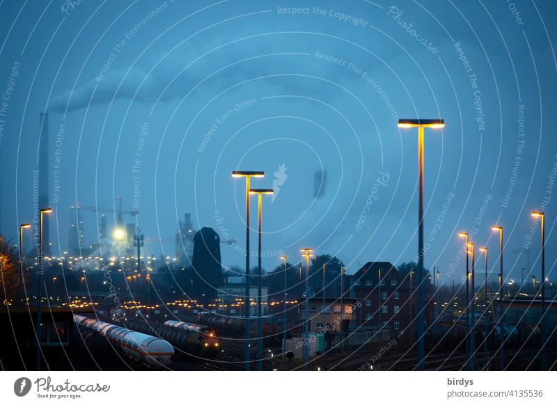 Industrial landscape with freight trains, industrial plants and blue hour lighting. Industry, logistics, rail traffic Industrial district Freight trains