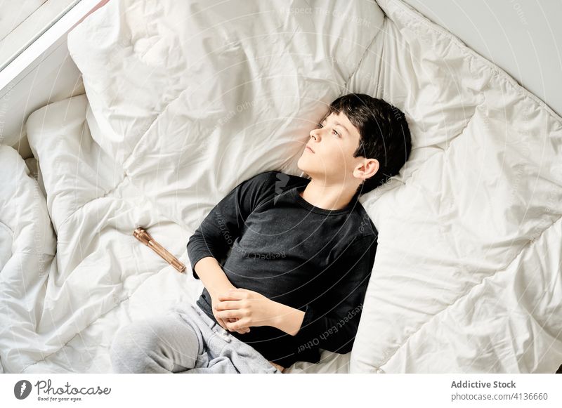 Tranquil boy lying on white blanket child home dream imagination calm enjoy weekend kid bed soft cozy window tranquil serene childhood comfort rest content