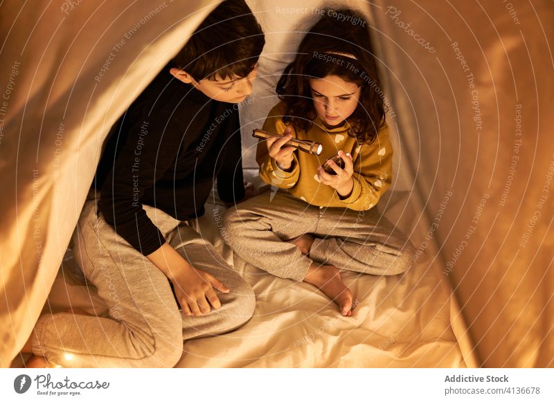Children sitting in kids play tent at home children garland spyglass night sibling together friendship childhood weekend legs crossed curious cozy brother