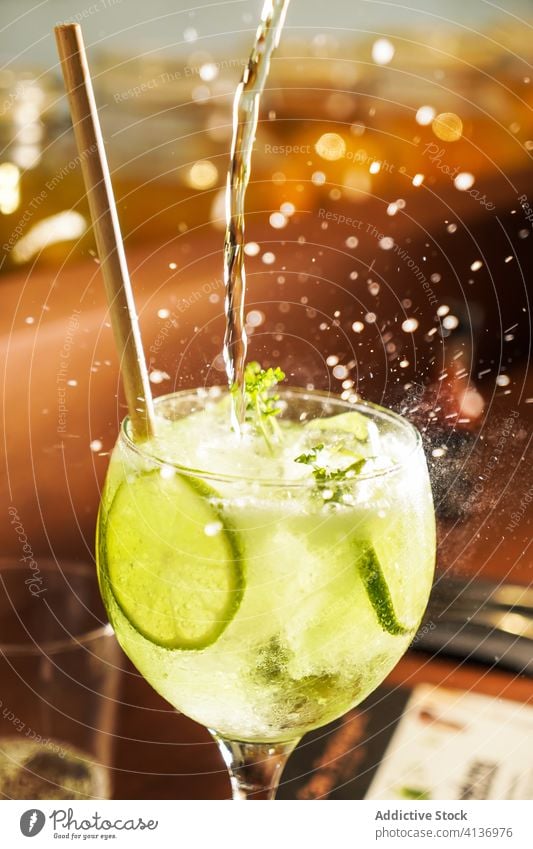 Refreshing mojito cocktail in glass crystal flow splash sweet alcohol beverage drink straw lime fruit tropical delicious lemonade cold refresh colorful