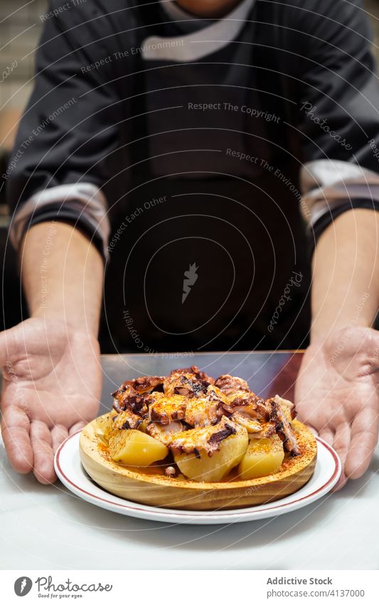Chef serving plate of potatoes with mushrooms dish cheese chef restaurant meal dinner cuisine gourmet fresh culinary delicious portion professional yummy