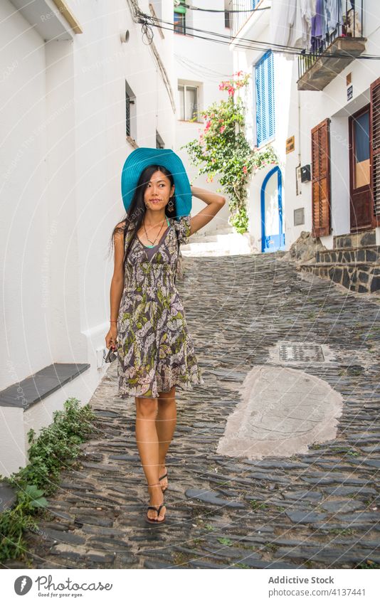 Ethnic woman walking on street of old town travel medieval architecture stone narrow young female asian ethnic summer style elegant cadaques girona spain