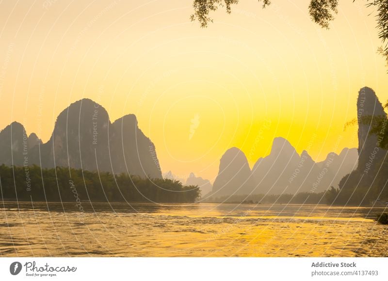 Tranquil landscape of river and rocks during sunset amazing sundown silhouette mountain evening ripple bright twilight nature yangshuo yangshuo county china