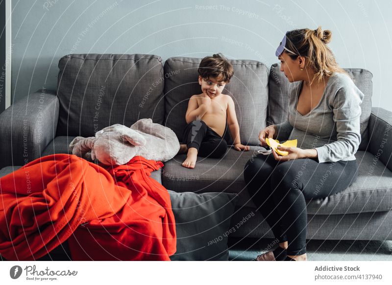 Mother and little son in living room during weekend mother create mask superhero together costume home having fun play imagination child parent childhood game