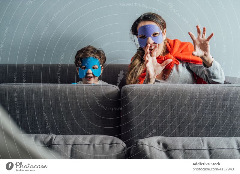 Creative mother and son in superhero masks at home play game creative pretend having fun playful cheerful little weekend boy kid child happy childhood joy