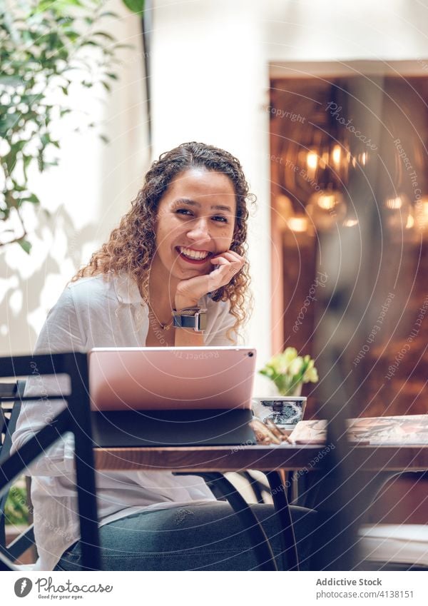 Cute woman with tablet in outdoor cafe smiling using young sitting casual happy female lifestyle palma de mallorca spain city town leisure rest relax restaurant