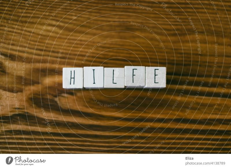 The word help written on wood with letter cubes Help Word authored helping helpful Support SOS Letters (alphabet) Wood cube of letters Emergency First Aid