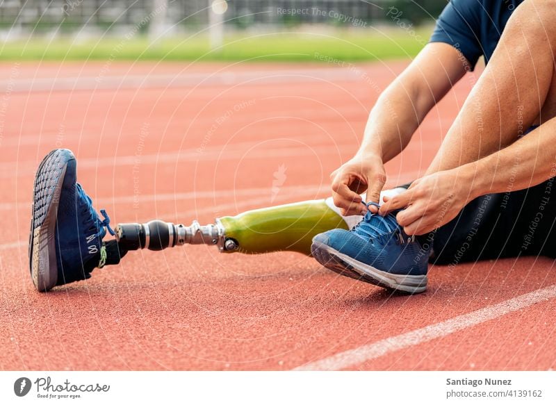 Close up disabled man athlete with leg prosthesis. trainers closeup runner portrait sport legs prosthetic faceless unrecognized anonymous sports wear