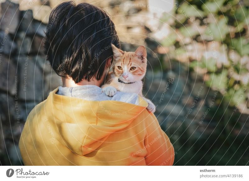 Back view of child with kitten kid pet cat pets love domestic stray homeless adorable people toddler baby lost outdoor small alone urban curiosity little street