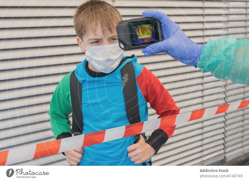Crop doctor measuring temperature with infrared camera during COVID 19 thermal coronavirus measure scan outbreak covid 19 check kid boy thermometer epidemic