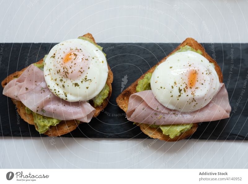 Toasts with ham and fried eggs on slate board toast breakfast guacamole tasty appetizing healthy food delicious table yummy fresh meal morning serve cuisine