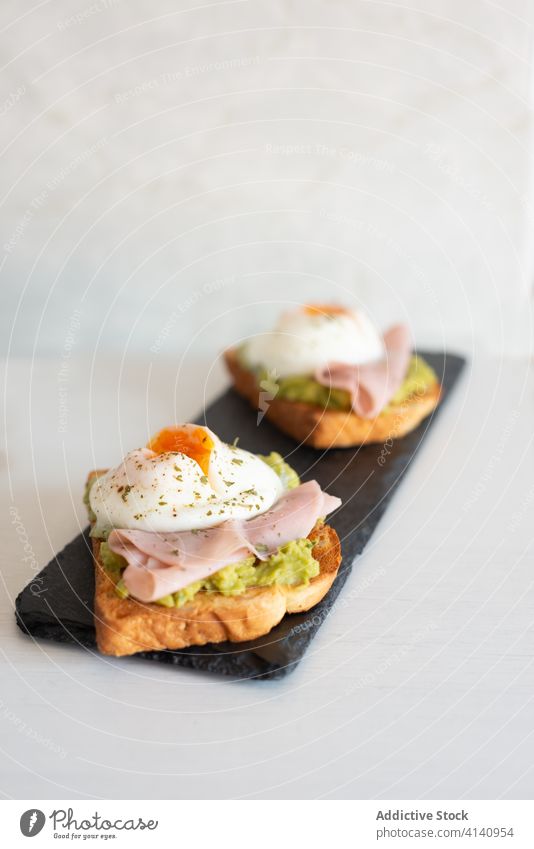 Delicious toasts with fried eggs and ham breakfast tasty slate board crispy kitchen guacamole appetizing healthy food delicious table yummy fresh meal morning
