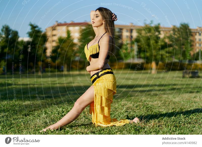 Slim ethnic woman in costume dancing in city belly dance posture dancer oriental tradition practice energy talent female grace smile pose flexible elegant move
