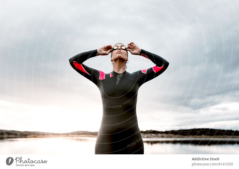 Woman in wetsuit wearing glasses on lake of shore woman diver goggles swimsuit extreme environment swimmer aqua sporty travel determine sportswoman vitality